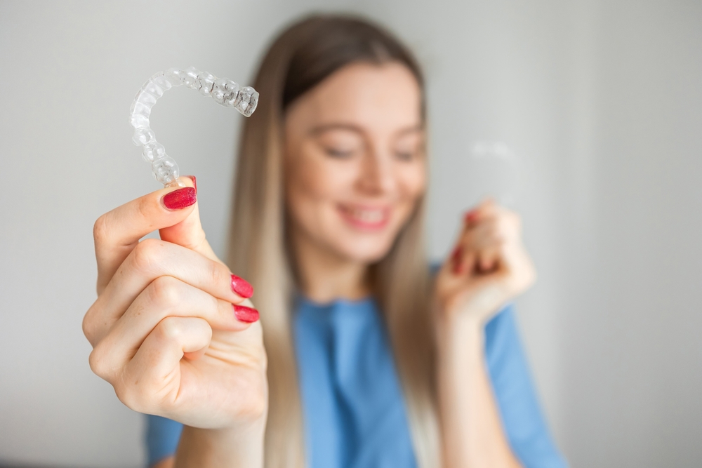 Clear Invisalign Aligner Close-Up – Invisalign in Austin, Texas Patient holding a clear Invisalign aligner, highlighting discreet, comfortable orthodontic treatment for straightening teeth – Invisalign in Austin, Texas