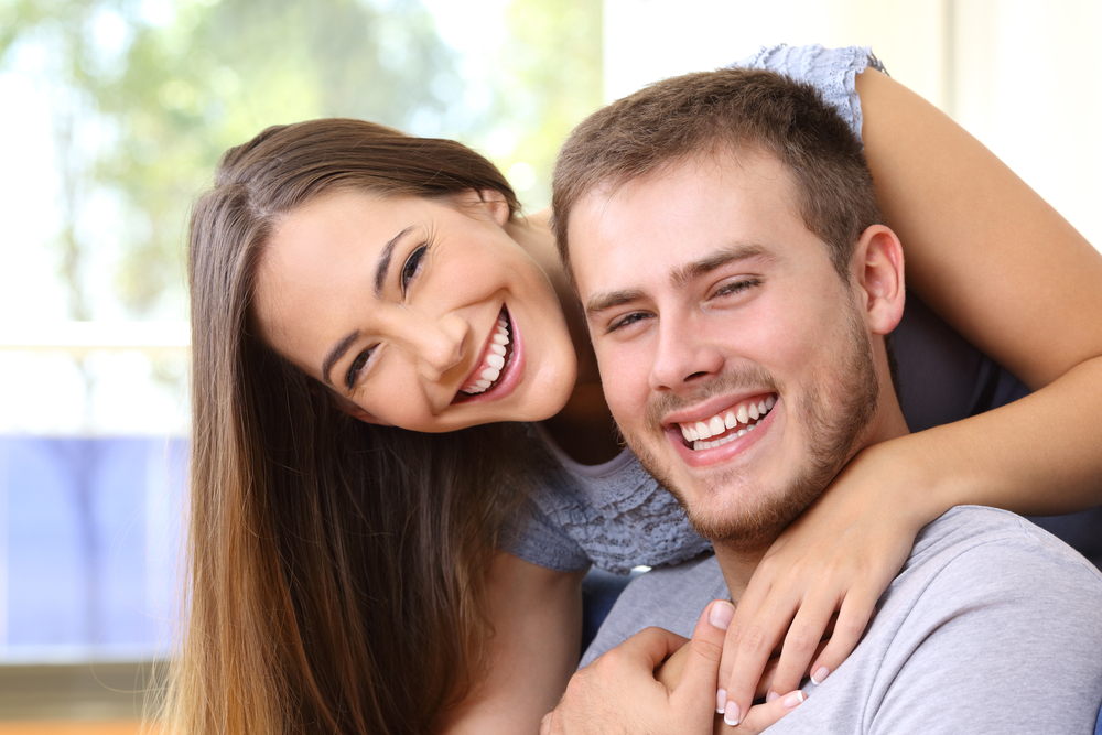Happy couple smiling together at home, reflecting smooth recovery and renewed comfort after wisdom teeth removal – Wisdom Teeth Removal in Austin