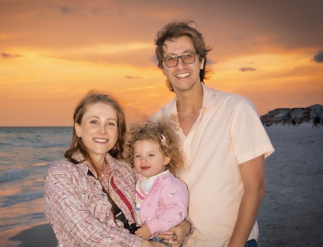 Happy family stacked on bed smiling together – TORC Dental Happy family smiling together – TORC Dental