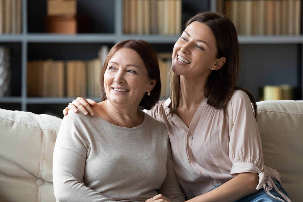 Two women smiling together in a relaxed home setting, reflecting renewed confidence and quality of life after dental bridge restoration – Dental Bridges in Austin