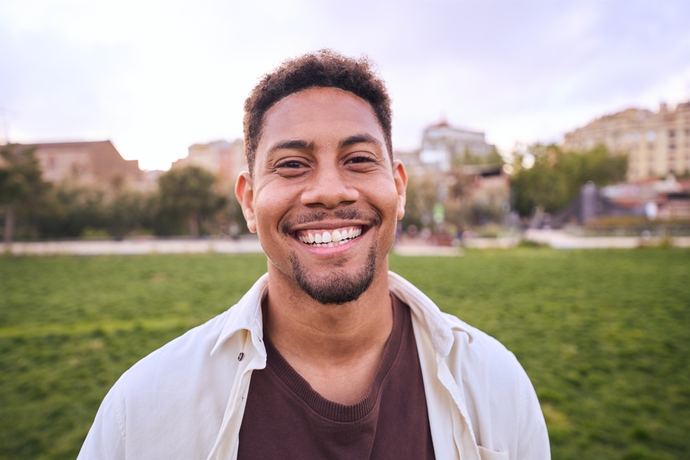 Whiter, Healthier Smile Results – Teeth Whitening in Austin Man smiling confidently outdoors in a park, showcasing the natural, long-lasting results of professional teeth whitening – Teeth Whitening in Austin