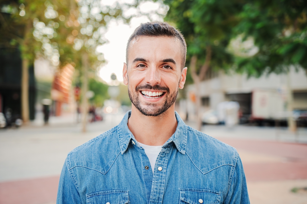 Confident Smile After Dental Implant Treatment – Dental Implants Dripping Springs Man smiling confidently outdoors, showcasing a healthy, natural-looking smile restored with advanced dental implant care – Dental Implants Dripping Springs