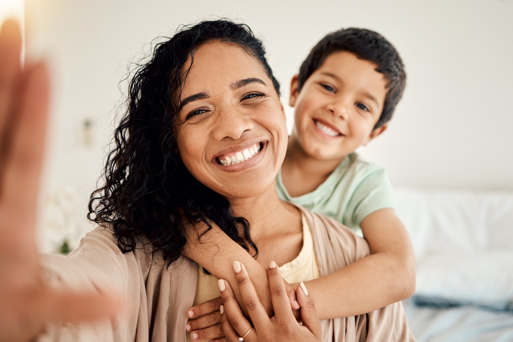 Mother and child smiling together at home, representing healthy smiles and preventive dental care through routine teeth cleanings – Teeth Cleaning in Austin