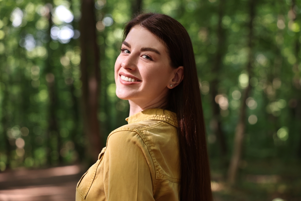 Natural Smile Restored with Dental Implants – Austin TX Dental Implants Woman smiling confidently outdoors, reflecting the functional and aesthetic benefits of modern dental implant restoration – Austin TX Dental Implants